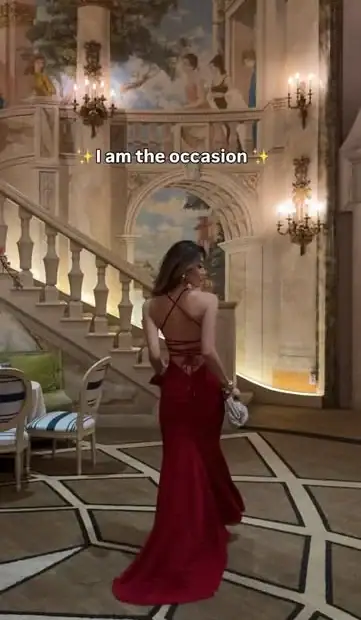 Kerina Wang in deep red Babyboo Olenia evening gown, open lace-up back, ballroom staircase